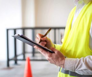 Kontrola stavby stavebním pracovníkem se stavebním deníkem na staveništi